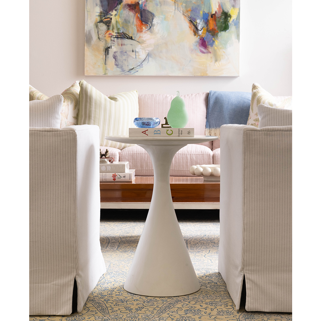 White ceramic Halo Bowl with smooth curved pedestal base on wooden coffee table.