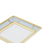 A light blue and yellow, square-shaped porcelain change tray with gold geometric patterns on the border.