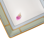 Heart-shaped pink pendant on a white surface with a gold frame