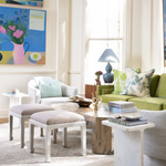 Living room with green sofa, white chairs, and decorative items.
