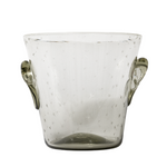 A clear glass ice bucket with hand-etched designs and two handles on the sides.