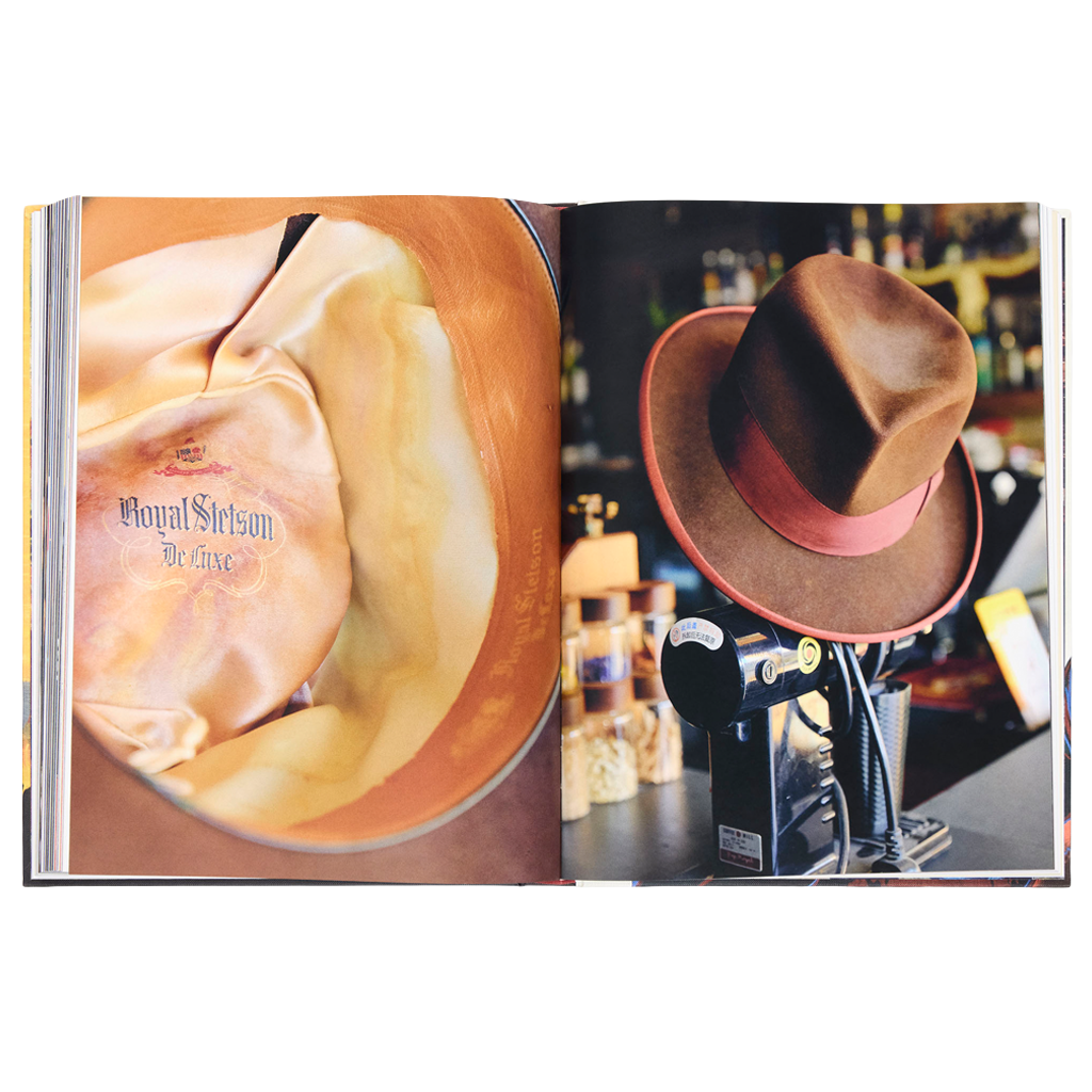 Open book showing a close-up of a bottle label and a hat on a stand.