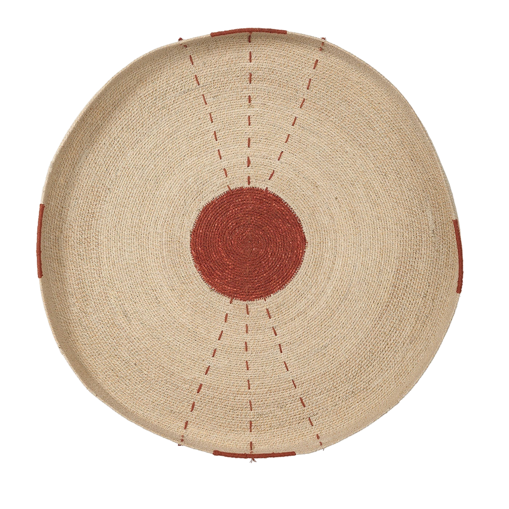 A round woven seagrass tray with a central rust-red circle and red dashed line details, shown from above on a white background.