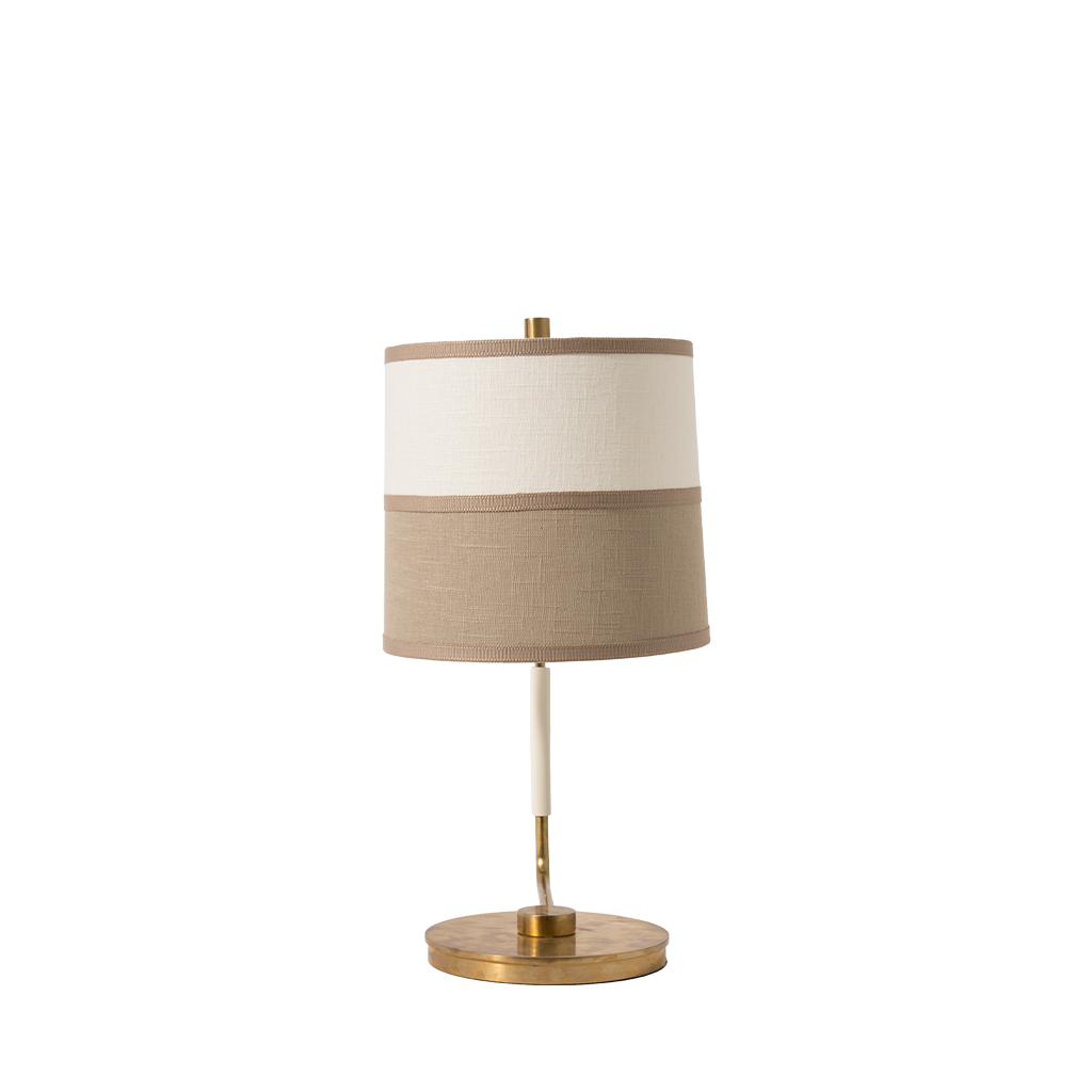 Table lamp with beige shade and brass base on a white background