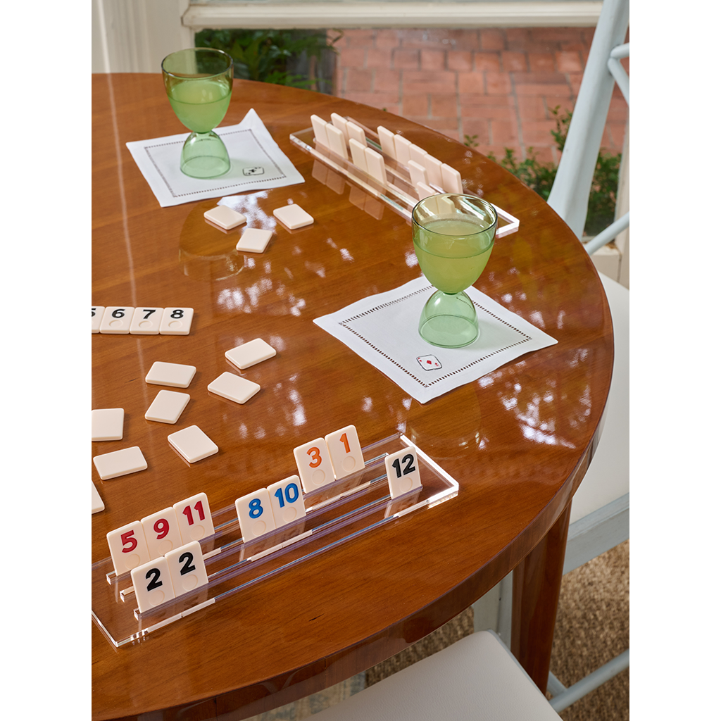 Set of two green glass martini glasses with wide bowls and short stems on a glossy wooden table.