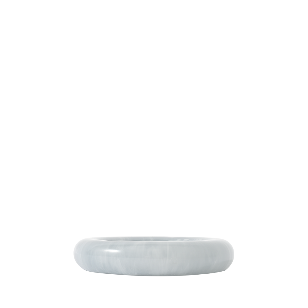 Side view of a round blue resin catch all dish on a white background