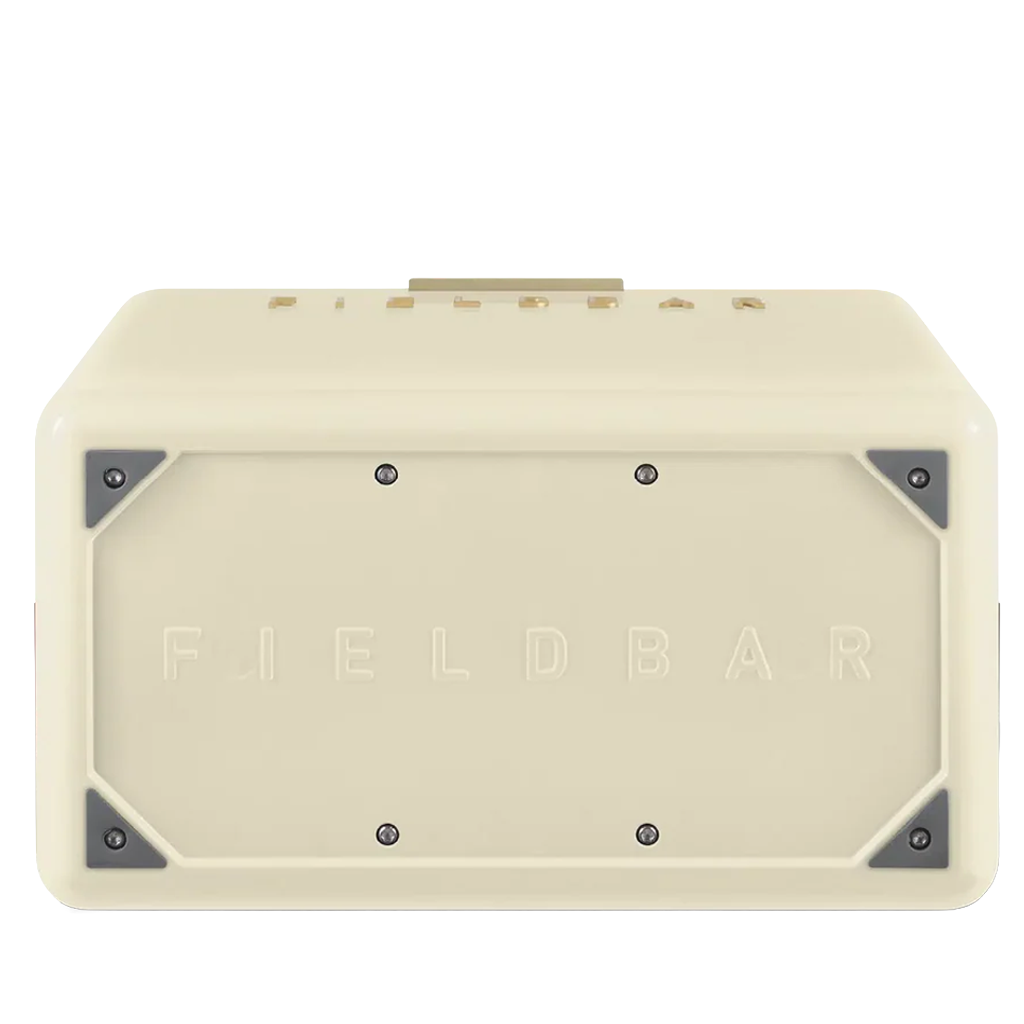 The underside of the cream FIELDBAR cooler is shown, featuring an embossed FIELDBAR logo centered on the base. Reinforced metal corner plates and exposed screws add durability while maintaining the cooler's premium design.