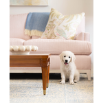 White decorative Halo Bowl with rounded bead design on wooden coffee table in front of pink sofa and pillows.