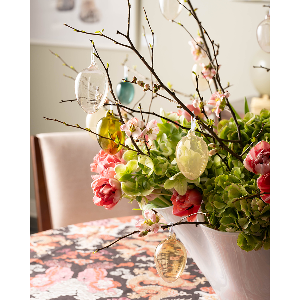 Vase with floral and branches with hanging glass easter eggs