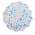 Round white placemat with scalloped edges featuring blue botanical and bird designs.