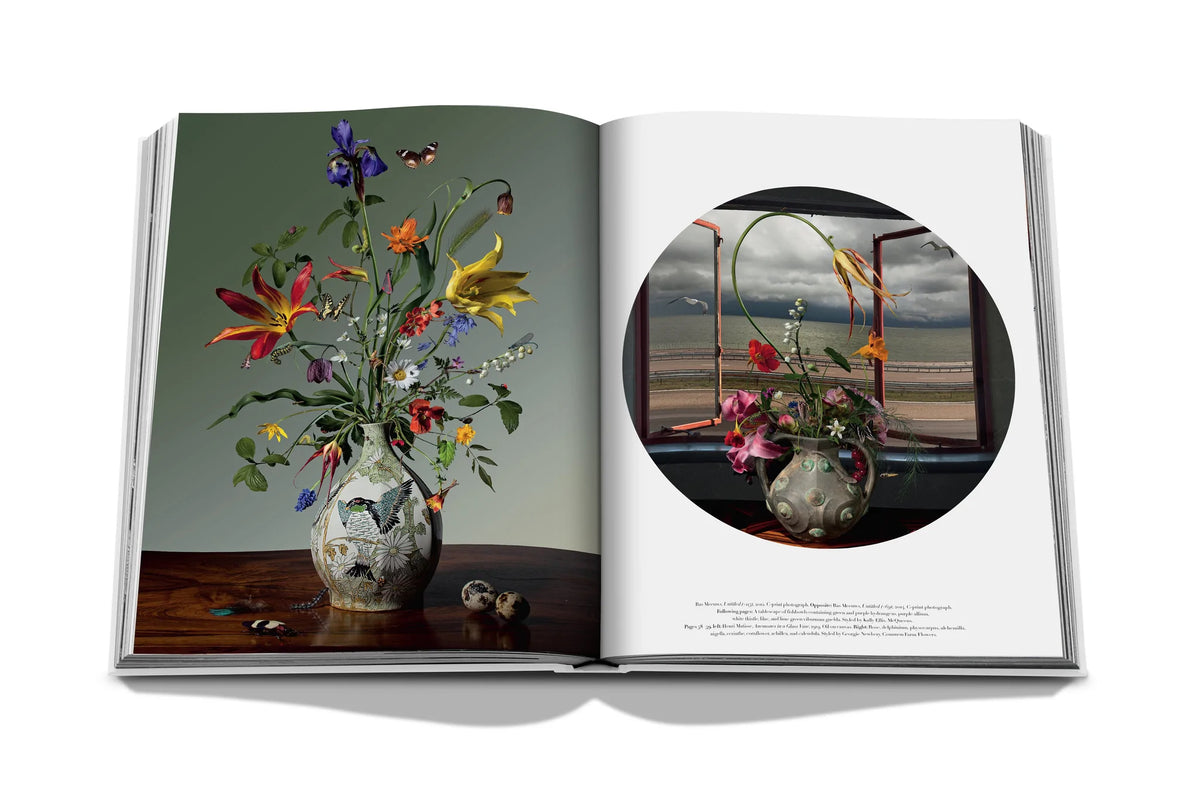 Open art book featuring detailed floral paintings with vibrant reds, yellows, and greens on glossy pages.