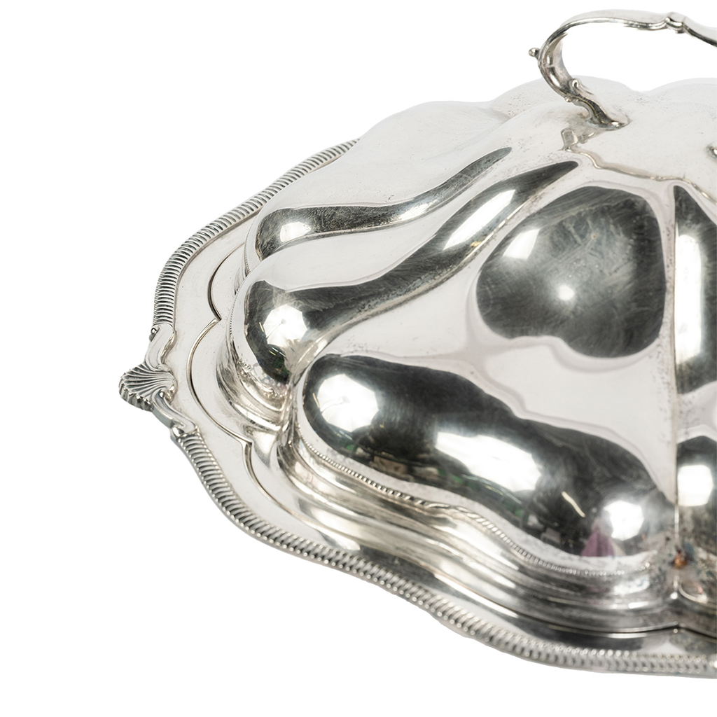 Up close shot of the silver tray with ridged edges, a dome lid with handle.