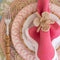 woven lily napkin ring on a tablescape with a pink napkin