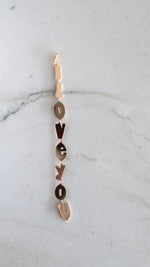 Gold bracelet with vertical "Love You" letters linked by small rings on a chain clasp.