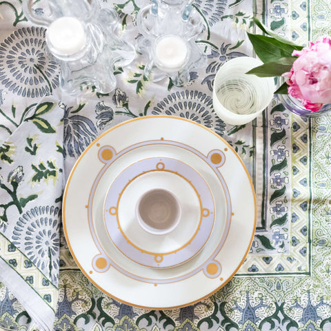 Maya Blue Tablecloth paired with matching napkin and dinner plate, tea cup and saucer, and glassware on top