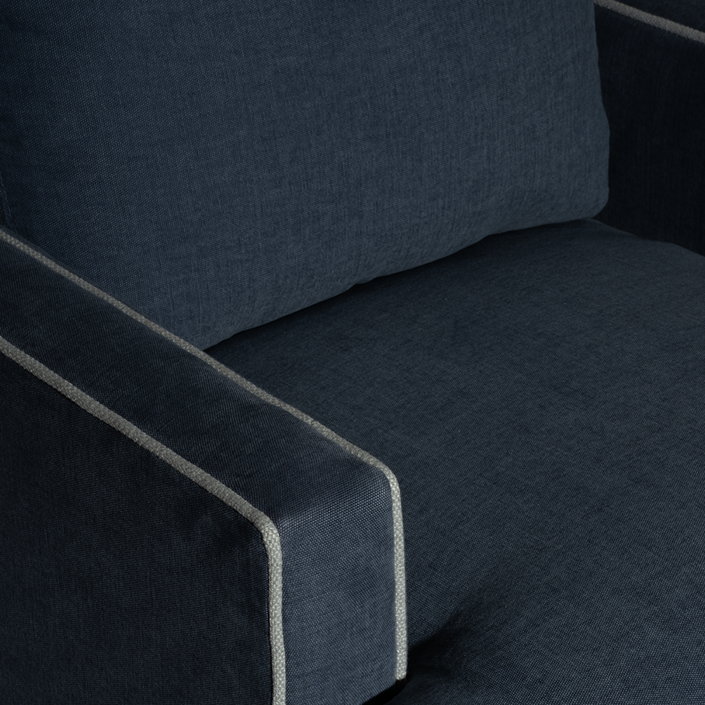 Close-up of a dark blue upholstered chair with armrest.