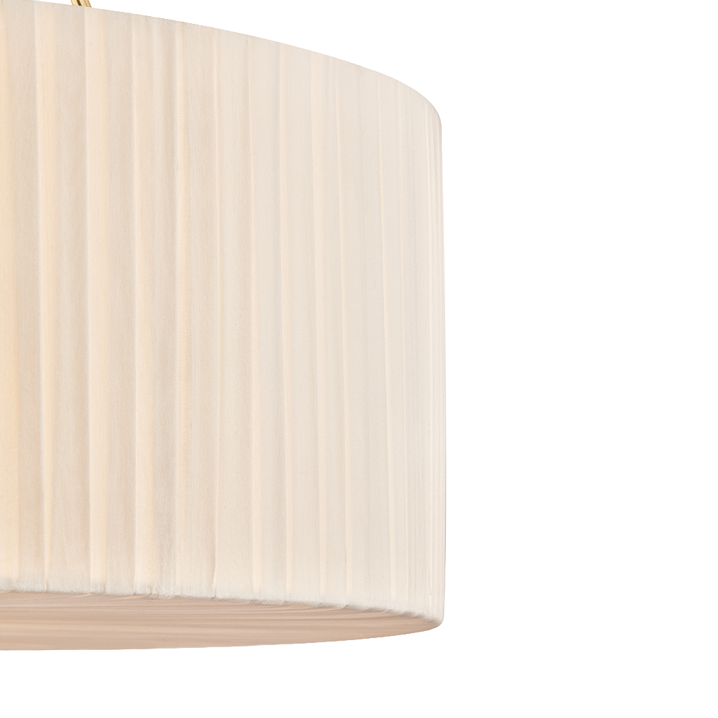 Close-up of a pleated drum lampshade in a warm cream or off-white color, showing vertical folds and a light wood-toned rim against a plain white background.