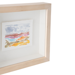 A light natural wood shadow box frame with a white mat, displaying a small colorful watercolor landscape painting on a white background.