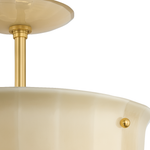 Close-up of a semi-flush mount ceiling light fixture with a warm cream-colored glass shade and polished gold/brass metal hardware against a white background.