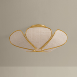 A modern semi-flush mount ceiling light fixture with a gold-finished metal frame and three textured beige fabric shades, shown against a neutral beige background.