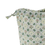 A close-up of a drawstring pouch made of light sage green fabric with a white geometric lattice pattern and small pink floral motifs, shown on a plain white background.