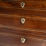 Close-up of a wooden drawer with brass keys