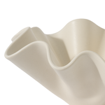 Beige ceramic vase with wavy design on a white background