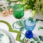 Blue martini glass next to a green glass on a table top