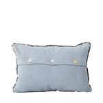 Light blue pillow with decorative buttons on a white background