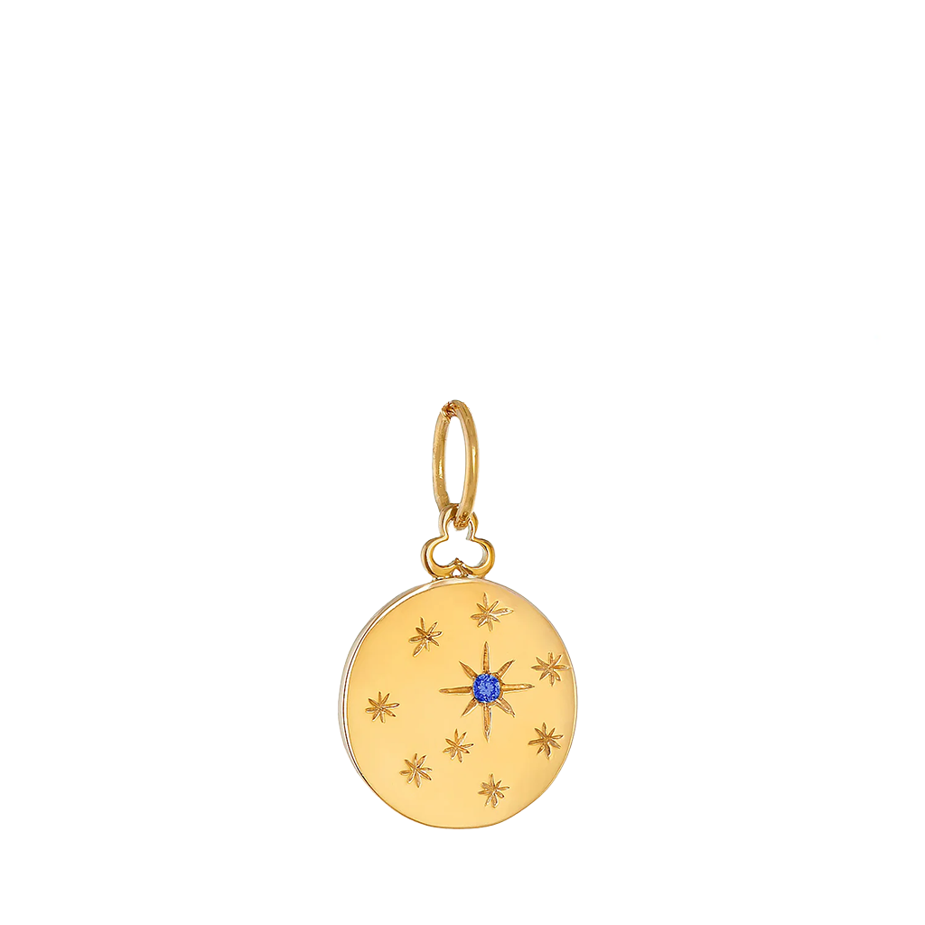 Yellow gold circular charm with engraved star-like shapes with one blue sapphire in the center of star