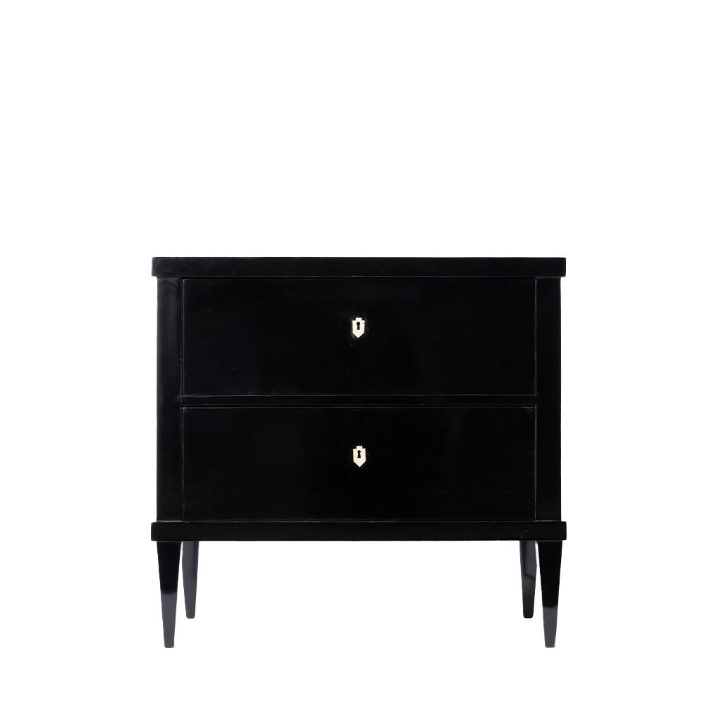 Front view of an antique ebonized two-drawer chest with a sleek black finish, clean lines, and tapered legs. Ivory-colored keyhole escutcheons provide a subtle contrast, emphasizing the piece's refined, minimalist design.