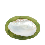 Green dish with a pearl inside on a white background