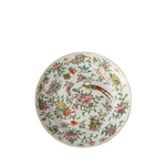 A round white porcelain plate decorated with a colorful hand-painted Chinese floral and bird pattern, featuring pink flowers, green leaves, and birds in orange, blue, and yellow, set against a plain white background.
