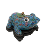 Decorative frog sculpture with intricate patterns on a white background