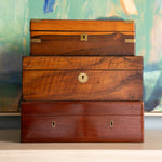 Stack of wooden boxes with brass locks against a colorful abstract background