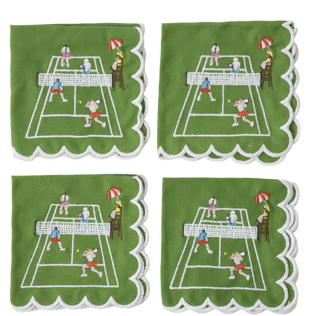 Four green square cloth napkins with scalloped white edges, each embroidered with a tennis court scene featuring players, a net, umpire, and ball.