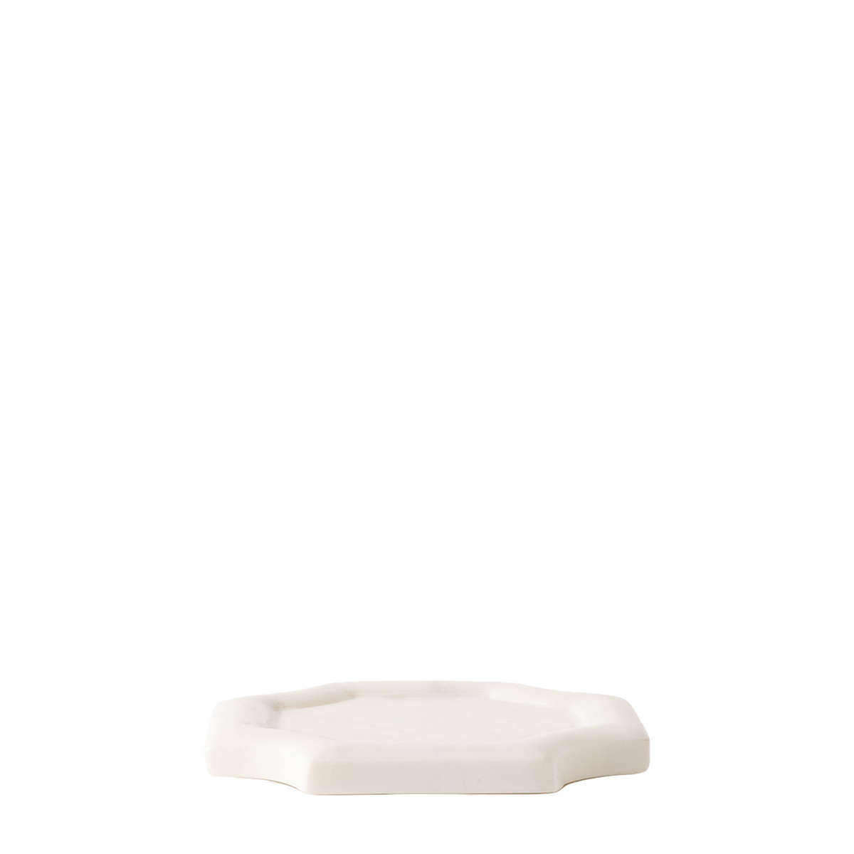 A small white ceramic tray with a scalloped octagonal edge, photographed against a seamless white background.