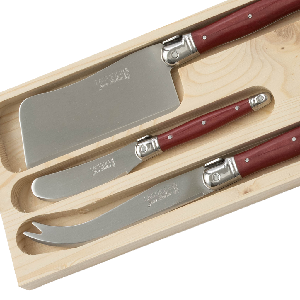 A three-piece Laguiole cheese knife set featuring red handles and stainless steel blades, presented in a fitted natural wood storage box. The set includes coordinating knives designed for slicing, spreading, and serving a variety of cheeses.