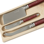 A three-piece Laguiole cheese knife set featuring red handles and stainless steel blades, presented in a fitted natural wood storage box. The set includes coordinating knives designed for slicing, spreading, and serving a variety of cheeses.