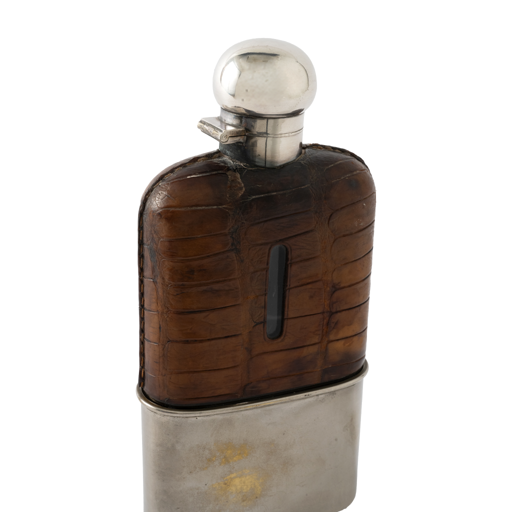 A vintage-style flask with a dark brown textured crocodile skin pattern on the upper body and a silver-toned metal base and cap, shown on a plain white background.