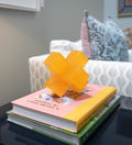 orange jack sculpture on stack of books