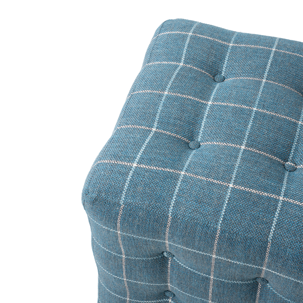 Blue checkered ottoman with tufted buttons on a white background
