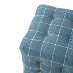 Blue checkered ottoman with tufted buttons on a white background