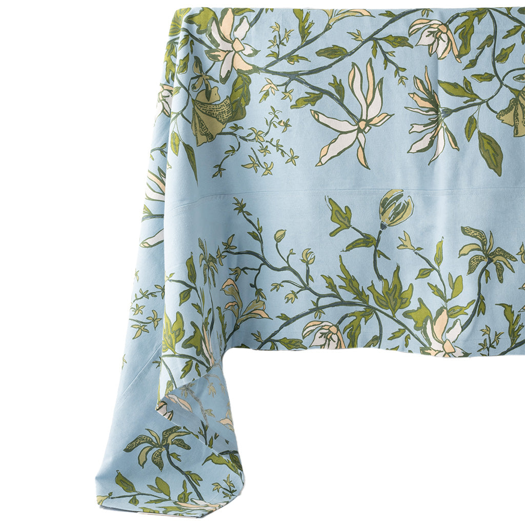 blue and green botanical tablecloth draped off a table on a white background