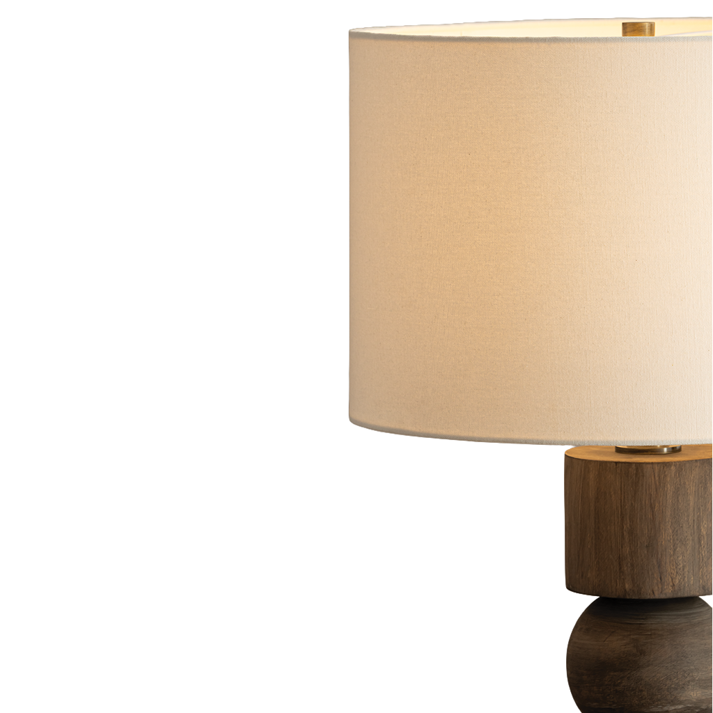 A close-up of a table lamp with a large cylindrical beige fabric shade and a dark wood base, shown against a plain white background.