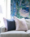 layered pillows on sofa with art
