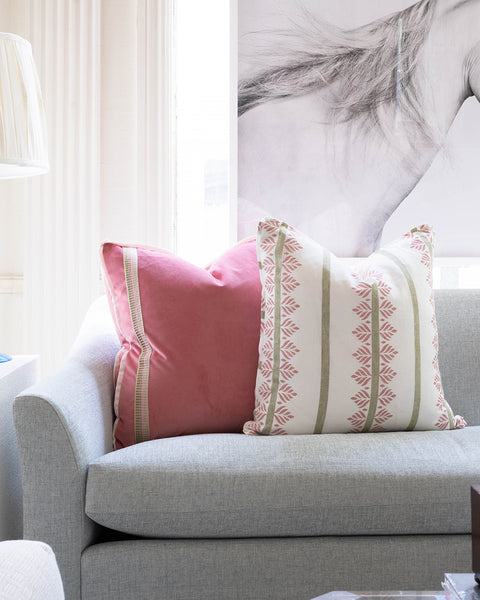two pillows in pink and green color scheme layered on sofa
