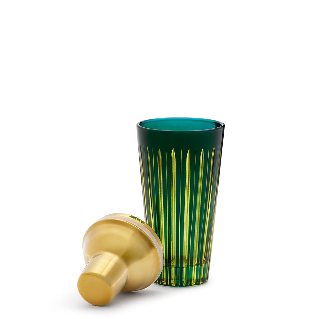 Green glass tumbler with gold cap on a white background