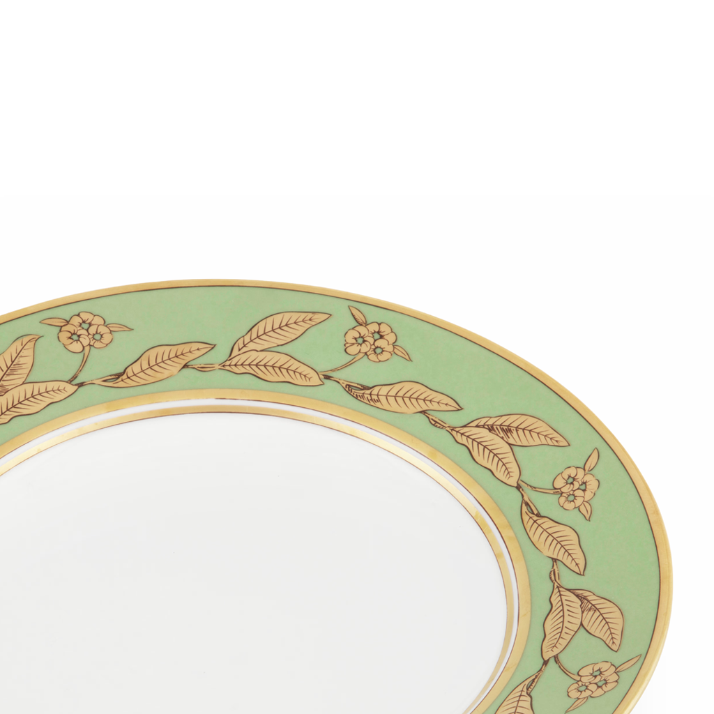 Decorative plate with gold leaf and flower pattern on a light green background