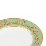 Decorative plate with gold leaf and flower pattern on a light green background